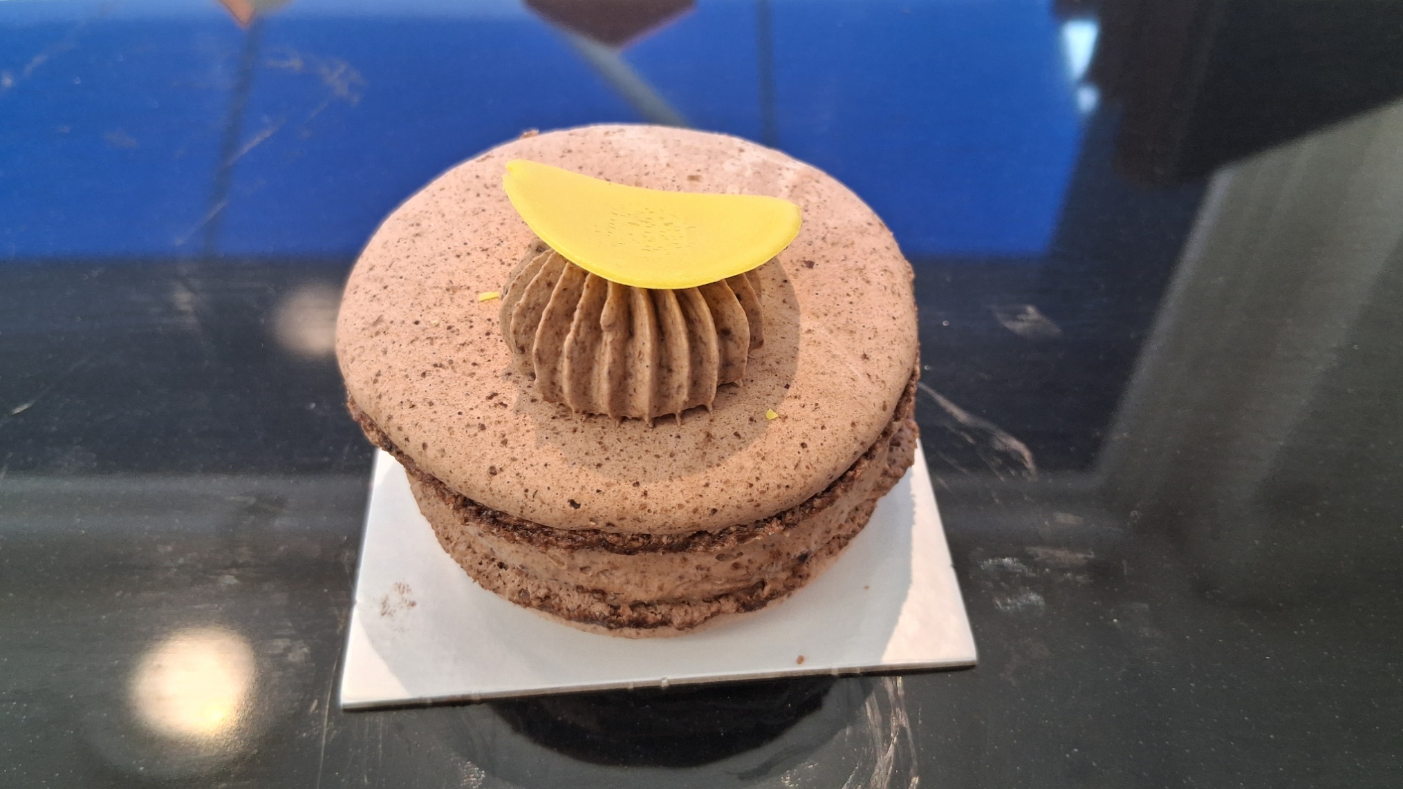 Macaron chocolat: Ganache chocolat noir 75%, macaron chocolat, éclat de fèves de cacao
